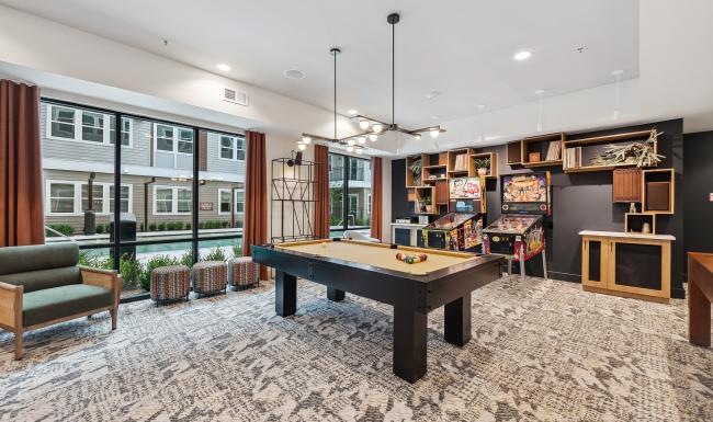a clubhouse room with a pool table and chairs