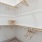 a closet with white walls and wooden beams