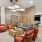 a clubhouse room with a wood floor, chairs, a table and a couch