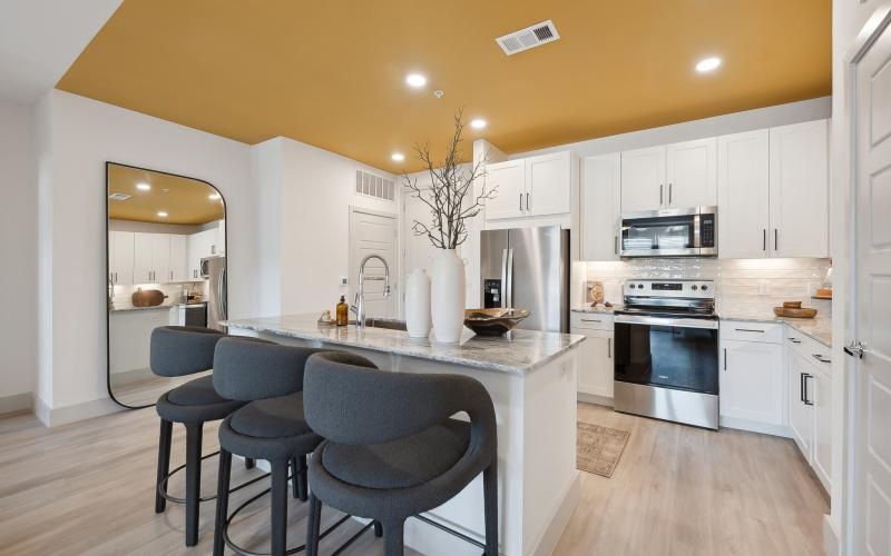 a kitchen with a bar stool and a table